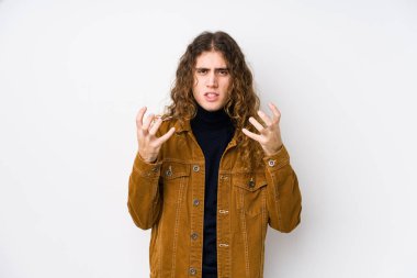 Uzun saçlı adam yalnız poz veriyor gergin elleriyle çığlık atıyor..