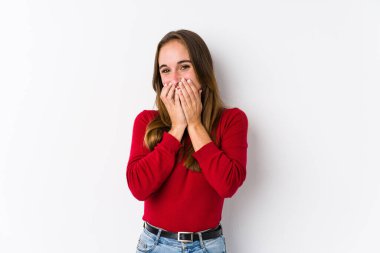 Kafkasyalı genç bir kadın yalnız poz veriyor. Bir şeye gülüyor, elleriyle ağzını kapatıyor..