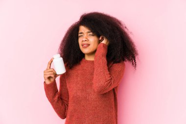 Vitamin taşıyan genç bir afro kadın. Vitaminli kulakları olan genç bir afro kadın..