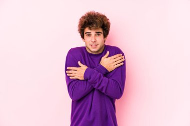 Pembe arka planı olan beyaz bir genç, düşük sıcaklıktan ya da hastalıktan dolayı soğuktan izole edilmiş..