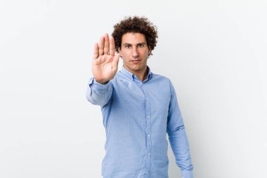 Genç, kıvırcık, olgun, zarif bir gömlek giyen, elini uzatmış, dur işareti gösteren, seni engelleyen bir adam..