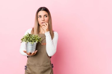 Çiçeği tutan genç bahçıvan kadın rahatlamış fotokopi odasına bakan bir şey düşünüyor..