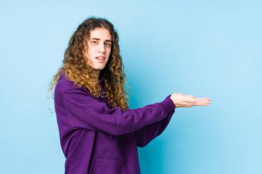 Uzun saçlı adam avucunun üzerinde bir kopya alanı tutuyormuş gibi poz veriyor..