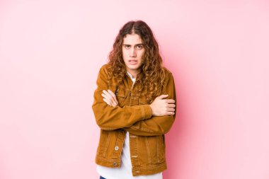 Genç, uzun saçlı bir adam poz veriyor. Düşük ateş ya da hastalık yüzünden soğuyor..