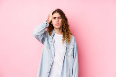 Uzun saçlı adam yalnız poz veriyor. Çok yorgun ve uykulu. Elini başının üstünde tutuyor..