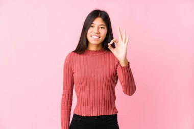 Genç Çinli kadın neşeli ve kendinden emin poz veriyor..