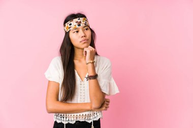 Genç Çinli hippi şüpheli ve kuşkulu bir ifadeyle yanlamasına görünüyor..