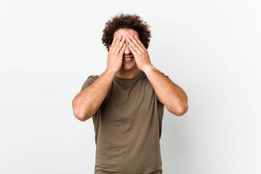 Olgun, yakışıklı bir adam izole edilmiş, elleriyle gözlerini kapatıyor, geniş bir gülümsemeyle bir sürpriz bekliyor..