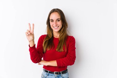 Genç beyaz kadın, izole edilmiş poz veriyor. İki numarayı parmaklarıyla gösteriyor..