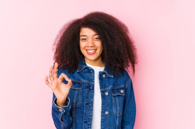 Genç Afro-Amerikan kadın neşeli ve kendinden emin, iyi bir jest yapıyor..