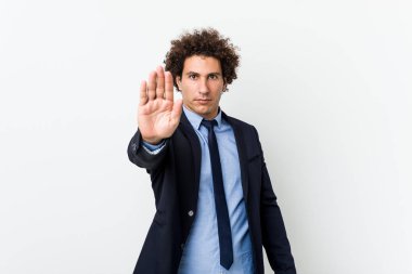 Genç iş adamı beyaz arka plana karşı elini uzatmış, dur işareti göstererek seni engelliyor..