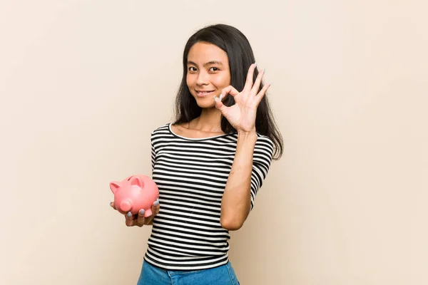 Mladý Asijské Žena Držení Prasátko Banka Veselý Jistý Ukazující Gesto — Stock fotografie