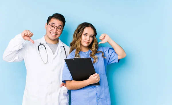 Young Doctor Couple Posing Blue Background Isolated Feels Proud Self — 스톡 사진