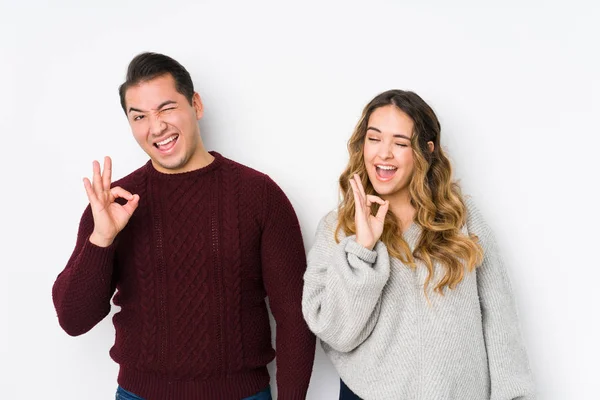 Jovem Casal Posando Fundo Branco Pisca Olho Mantém Gesto Com — Fotografia de Stock