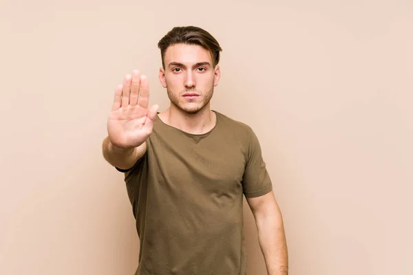 Młody Biały Mężczyzna Pozował Samotnie Wyciągniętą Ręką Pokazując Znak Stopu — Zdjęcie stockowe