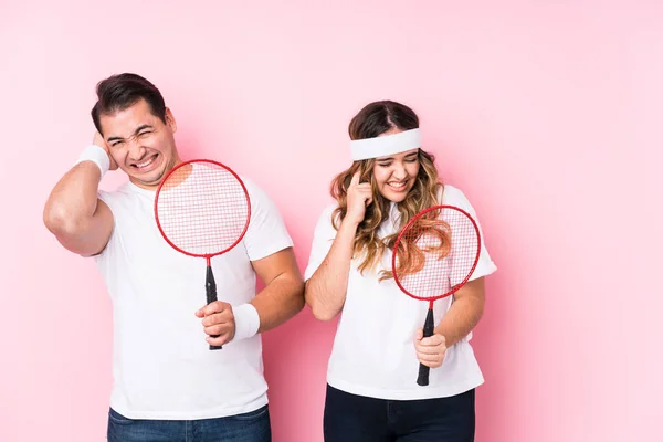 Casal Jovem Jogando Badminton Isolado Cobrindo Orelhas Com Mãos — Fotografia de Stock