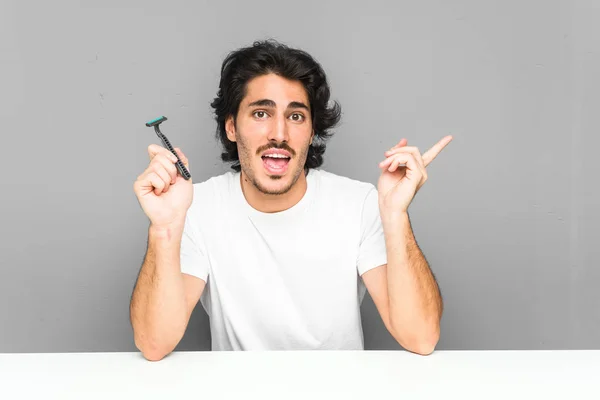 Jongeman Met Een Scheermes Glimlachend Vrolijk Wijzend Met Wijsvinger Weg — Stockfoto