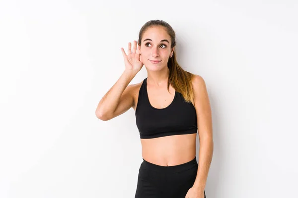 Joven Caucásica Fitness Mujer Posando Fondo Blanco Tratando Escuchar Chisme —  Fotos de Stock