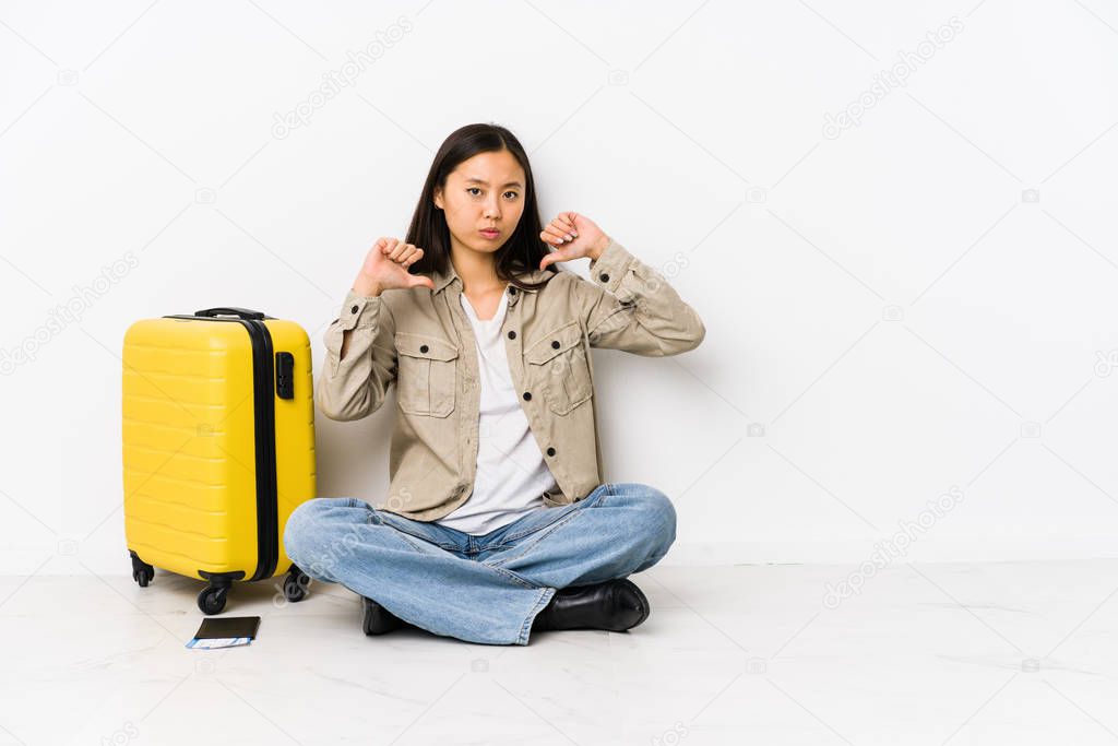 Young chinese traveler woman sitting holding a boarding passes feels proud and self confident, example to follow.