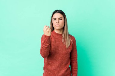 Kameraya yumruk sallayan, agresif yüz ifadesi takınan beyaz bir kadın..