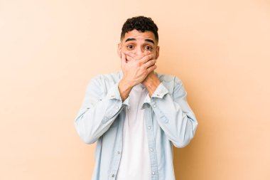 Genç, melez, Arap bir adam izole edilmiş. Ağzını elleriyle kapatmış..