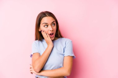 İzole edilmiş kayak kıyafetleri giyen genç beyaz kadın gizli bir sıcak fren haberi veriyor ve yan bakıyor.