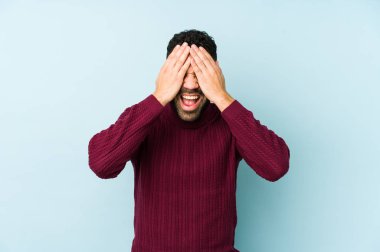 Genç, melez, Arap bir adam izole edilmiş, elleriyle gözlerini kapatmış, gülümseyerek bir sürpriz bekliyor..