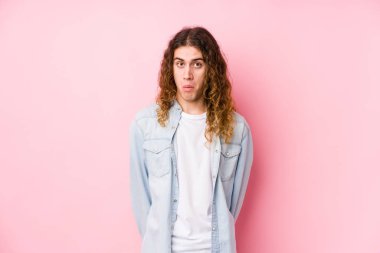 Uzun saçlı adam münzevi omuz silkiyor ve gözleri açık..