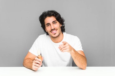 Genç adam sakalını tıraş ediyor. Neşeli gülümsemeler öne bakıyor..