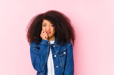 Young african american woman biting fingernails, nervous and very anxious.