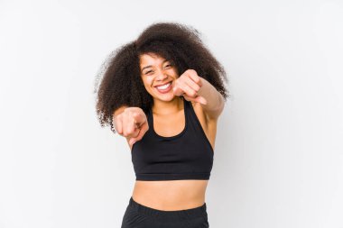 Young african american sporty woman cheerful smiles pointing to front.