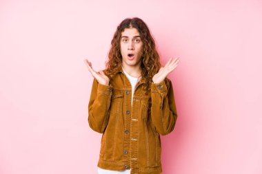 Genç uzun saçlı adam yalnız poz veriyor. Şaşırmış ve şok olmuş..