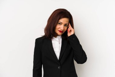 Orta yaşlı Latin iş kadını, tapınağı parmağıyla göstererek, düşünerek, bir göreve odaklanmış..