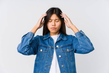 Genç Asyalı kadın tapınaklara dokunuyor ve baş ağrısı çekiyor..