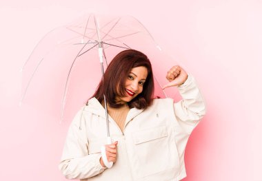 Orta yaşlı şemsiye takan Latin bir kadın kendini gururlu ve kendinden emin hissediyor, örnek olarak..