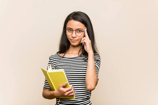 Young Asian Woman Student Holding Book Pointing Temple Finger Thinking — Stock Photo, Image