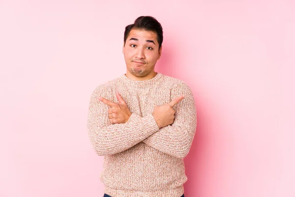 Young Curvy Man Posing Pink Background Isolated Points Sideways Trying — 스톡 사진