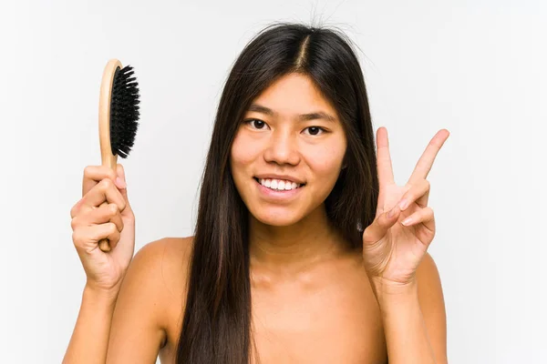 Junge Chinesin Hält Isoliert Eine Haarbürste Zeigt Siegeszeichen Und Lächelt — Stockfoto