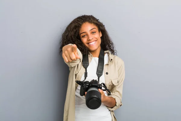 若いアフリカ系アメリカ人の写真家の女性がカメラを持って明るい笑顔を前に指して — ストック写真