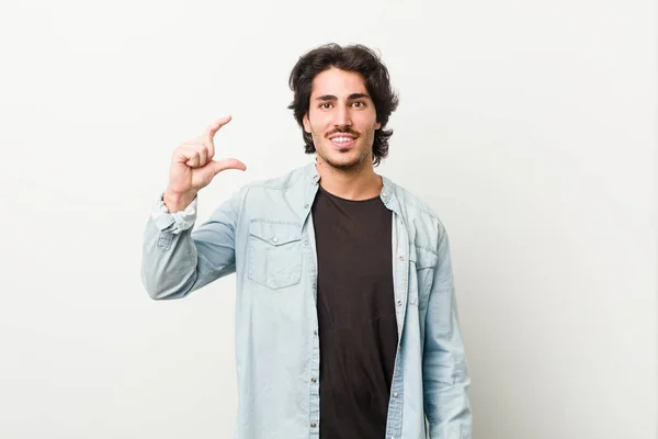 Homem Bonito Jovem Contra Fundo Branco Segurando Algo Pouco Com — Fotografia de Stock