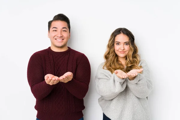 Young Couple Posing White Background Holding Something Palms Offering Camera — 스톡 사진