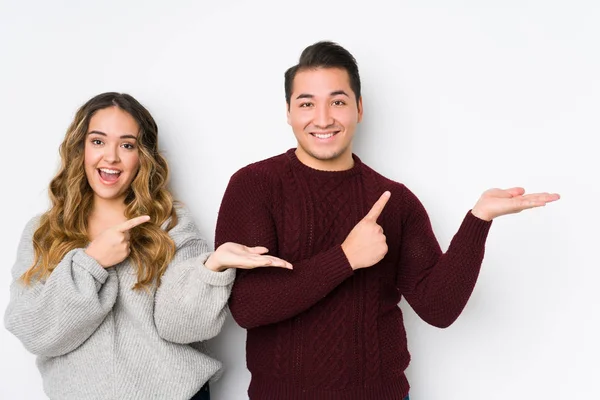 Pareja Joven Posando Fondo Blanco Emocionada Sosteniendo Espacio Copia Palma — Foto de Stock