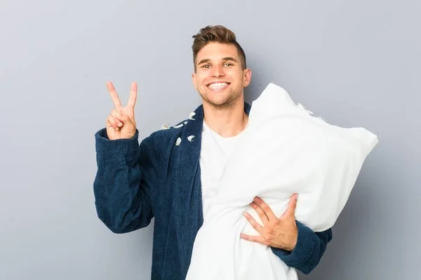 Молодой Человек Пижаме Держа Подушку Показывает Номер Два Пальцами — стоковое фото