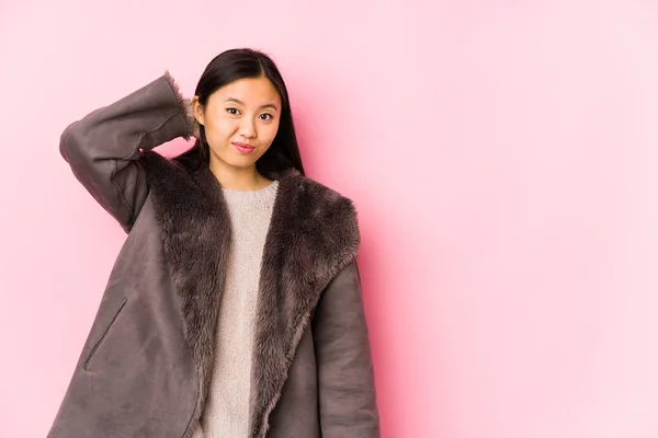 年轻的中国女人穿着一件孤立的外套 与后脑勺相碰 思考着 做出选择 — 图库照片