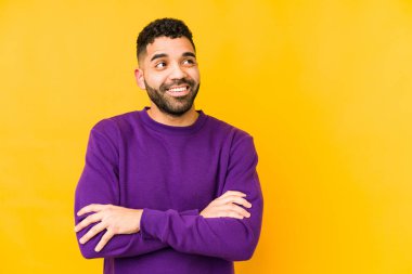 Genç, melez Arap bir adam izole edilmiş. Kollarını kavuşturup gülümsüyor..