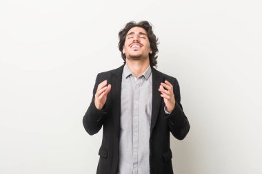 Genç iş adamına karşı beyaz bir arka plan neşeli bir kahkaha. Mutluluk kavramı.