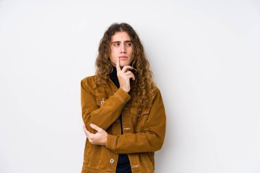 Uzun saçlı adam izole edilmiş poz veriyor. Bir şeyin fotokopi odasına baktığını düşünüyor..