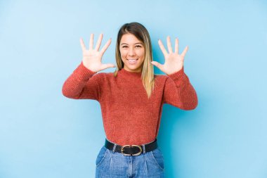 Kafkasyalı genç bir kadın yalnız poz veriyor. 10 numarayı elleriyle gösteriyor..