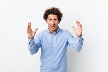 Zarif bir gömlek giyen genç, kıvırcık, olgun bir adam hoş bir sürpriz yapıyor, heyecanlı ve el kaldırıyor..