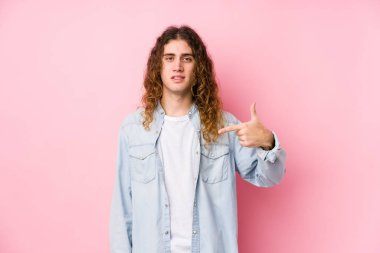 Uzun saçlı, izole edilmiş biri gibi poz veren, gömlek fotokopisini çeken, gururlu ve kendinden emin bir adam.